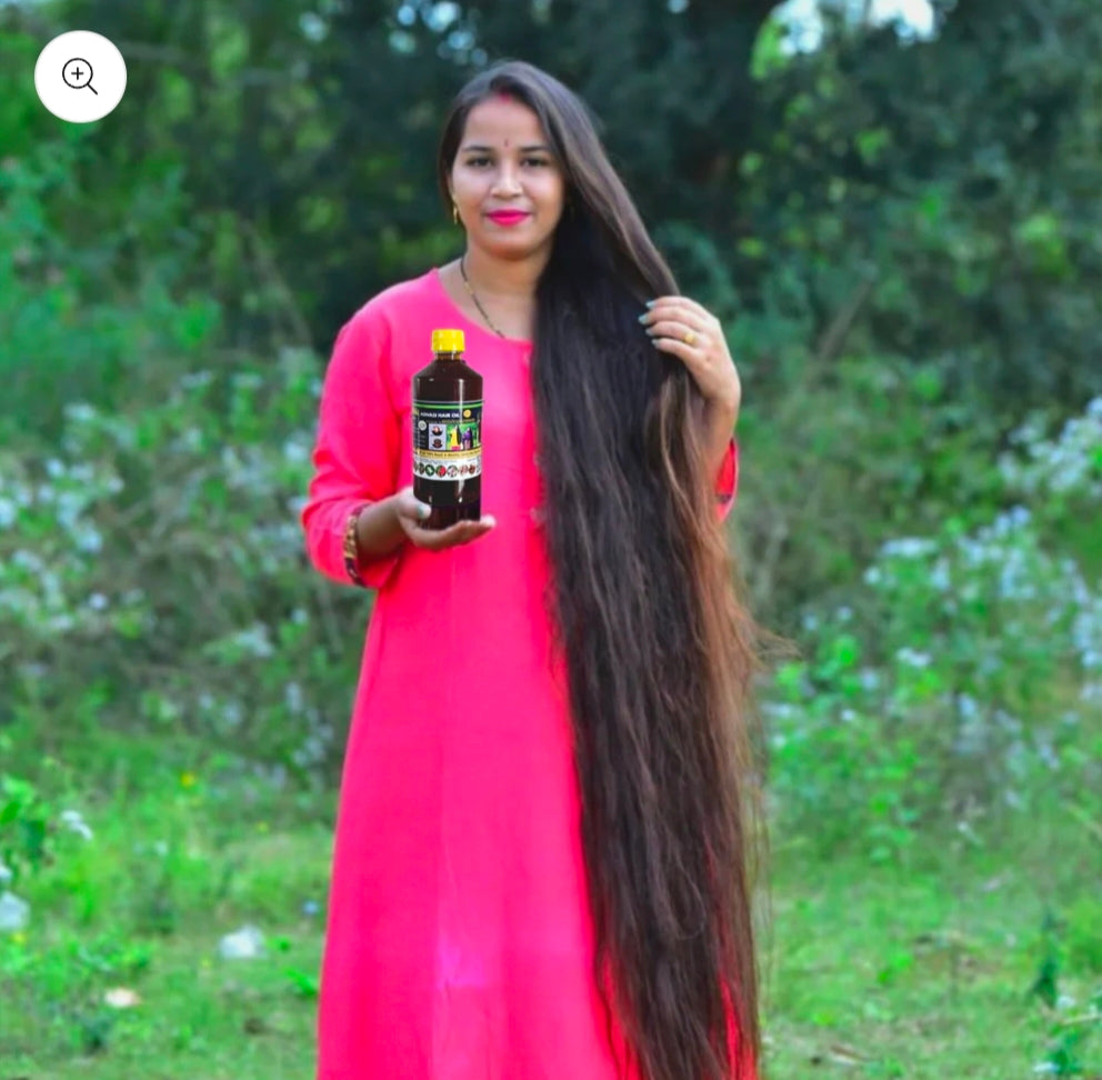 Woman with long hair holding a Hakki-Pikki_Herbal_Hair_Oil bottle outdoors
