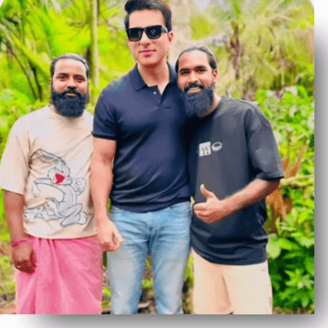 Three men posing together outdoors with greenery in the background