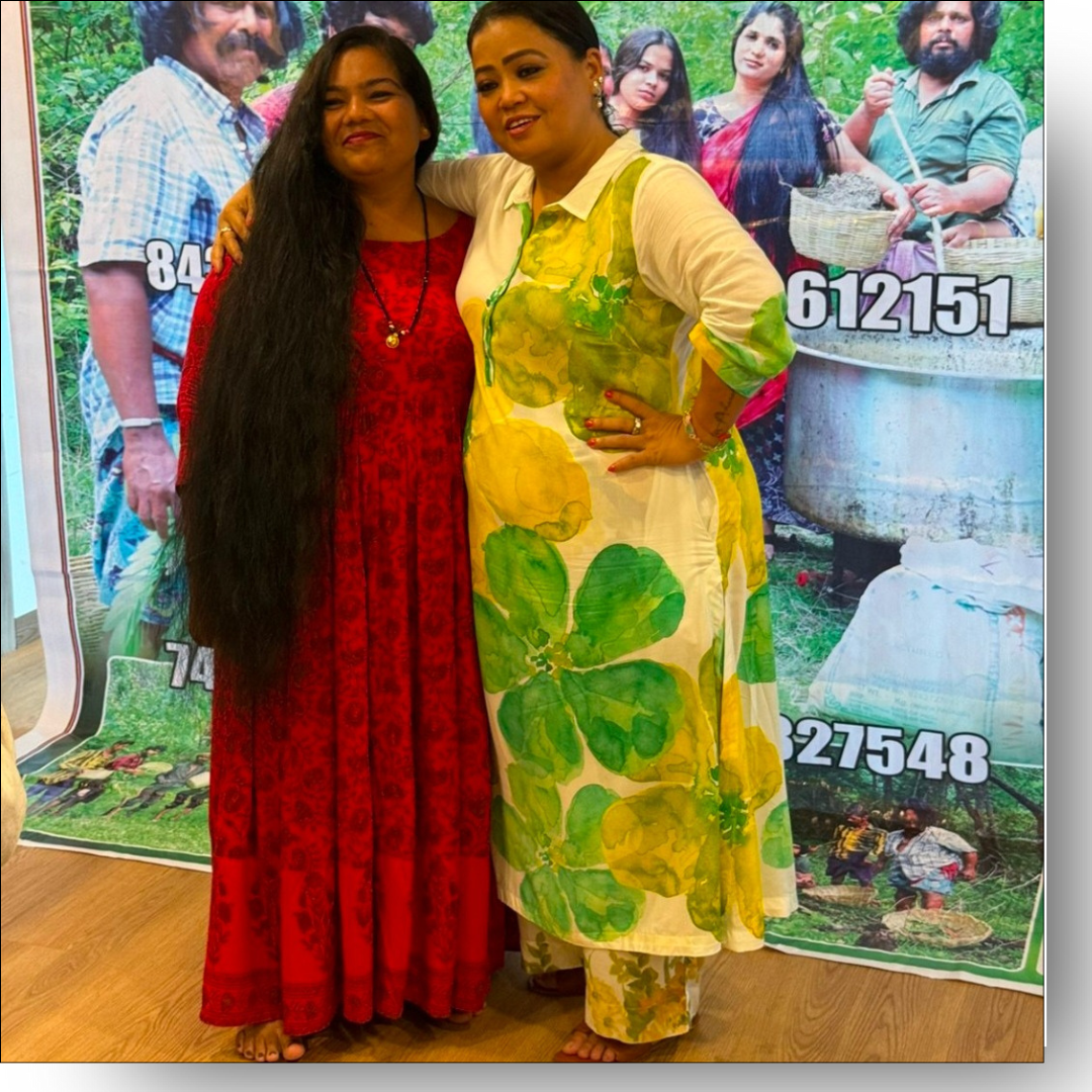 Two women posing together with a promotional poster in the background
