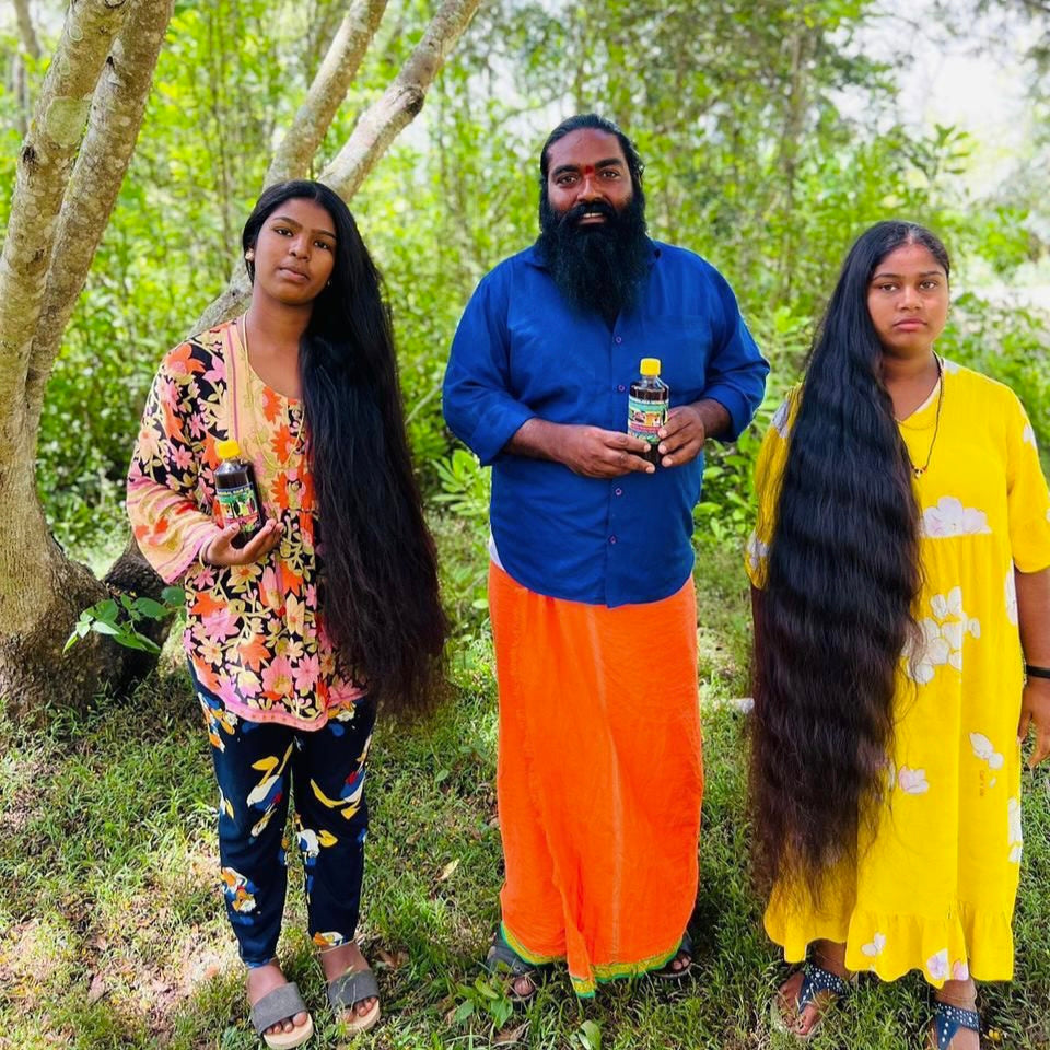 Three people with long hair standing outdoors in a forest setting.
